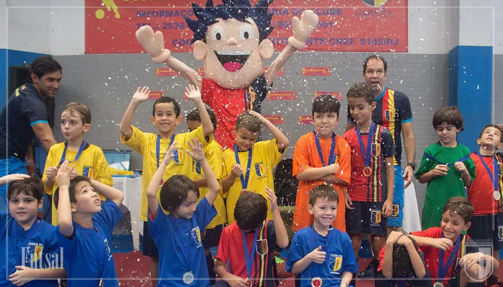 Crianças comemorando título em campeonato de futsal